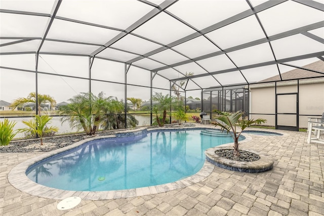 view of swimming pool with glass enclosure, an in ground hot tub, a patio area, and a water view