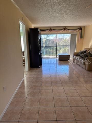 interior space featuring light tile patterned floors, crown molding, and a textured ceiling