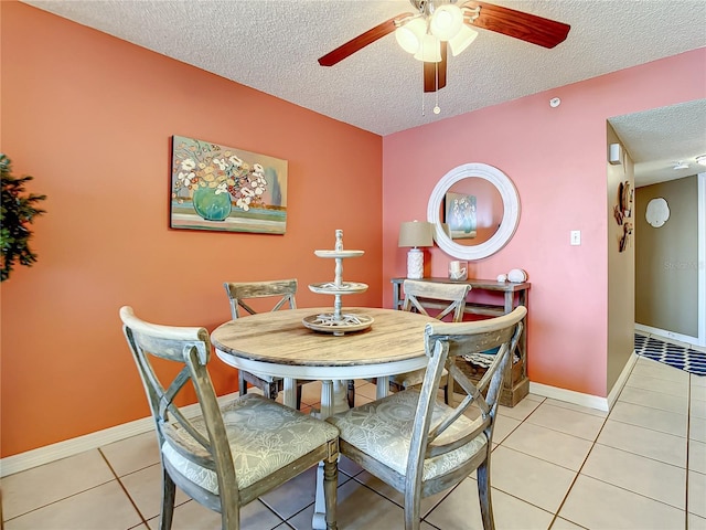 dining area with ceiling fan, light tile patterned floors, and a textured ceiling