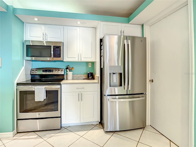 kitchen featuring light tile patterned floors, white cabinetry, and appliances with stainless steel finishes