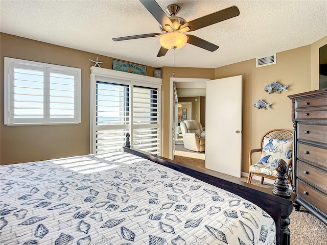 bedroom featuring ceiling fan, a textured ceiling, and carpet