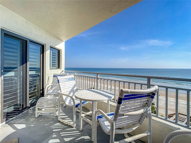 balcony featuring a water view and a beach view