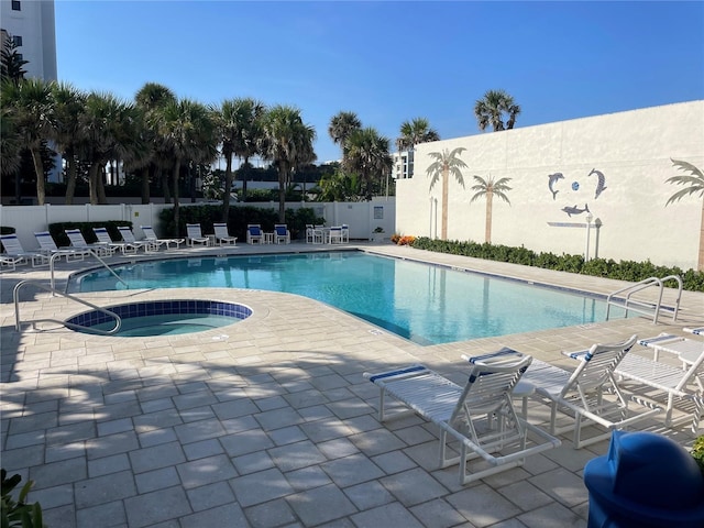 view of swimming pool featuring a hot tub and a patio area