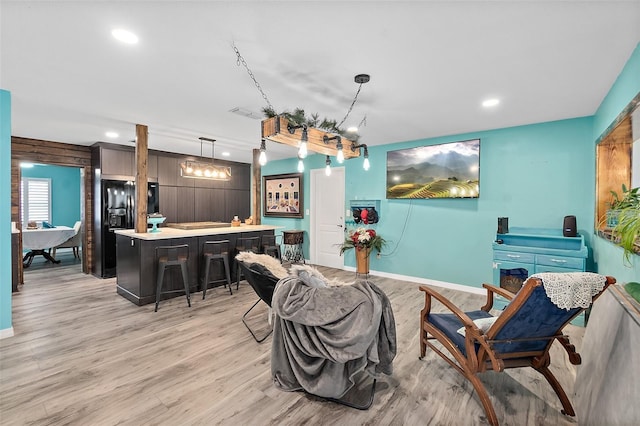 interior space with indoor bar, light hardwood / wood-style flooring, and wooden walls