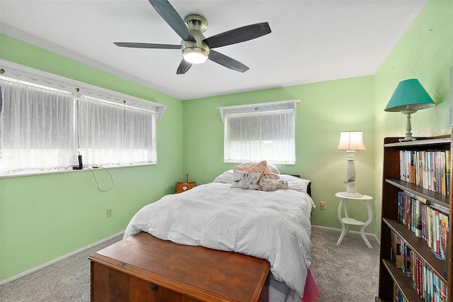 carpeted bedroom featuring ceiling fan and multiple windows