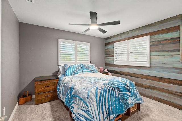 bedroom featuring ceiling fan, carpet, and wooden walls