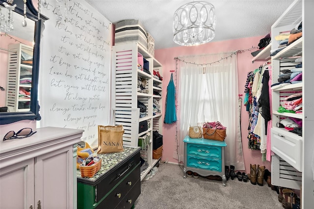 spacious closet with light carpet and a notable chandelier