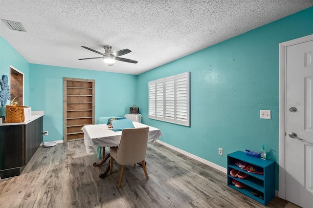 dining room with light hardwood / wood-style floors, a textured ceiling, built in features, and ceiling fan