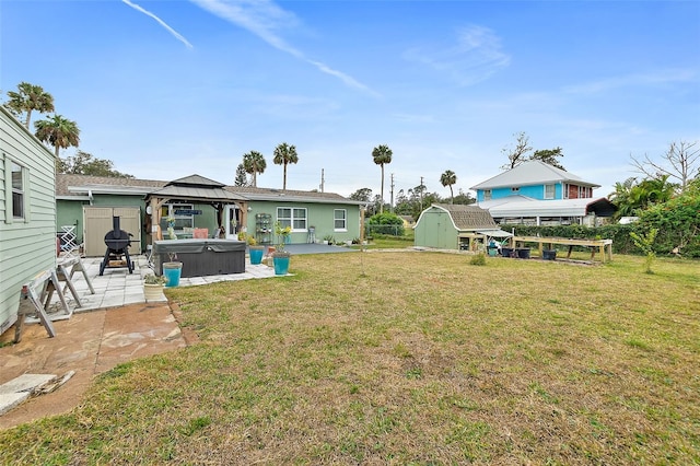 view of yard featuring a patio area, a gazebo, a hot tub, and a storage shed