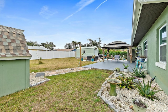 view of yard featuring a patio area, a gazebo, and a storage shed