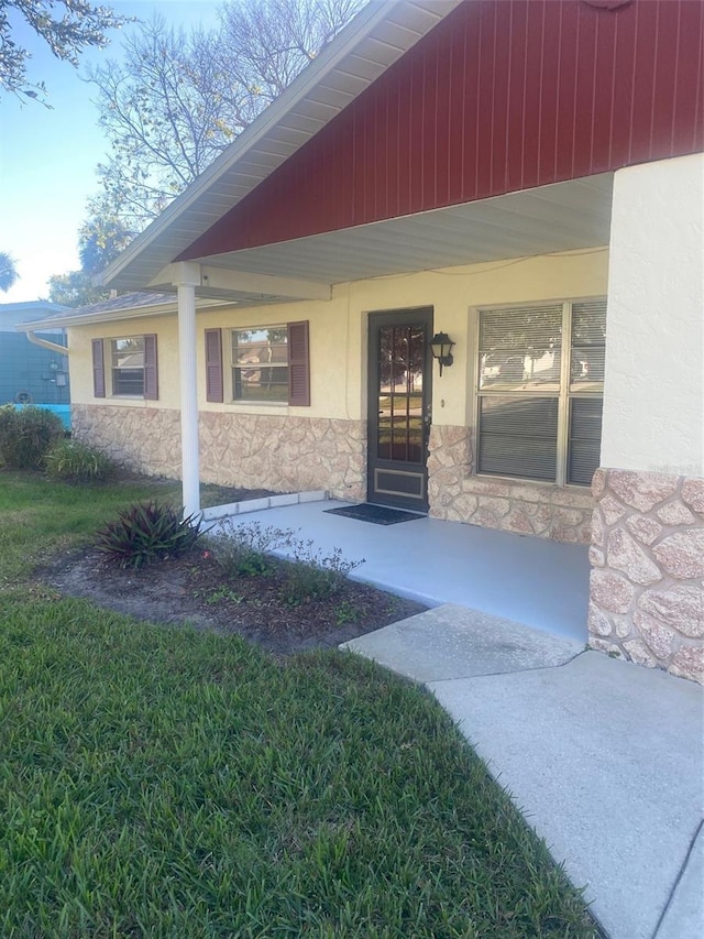 entrance to property with a lawn