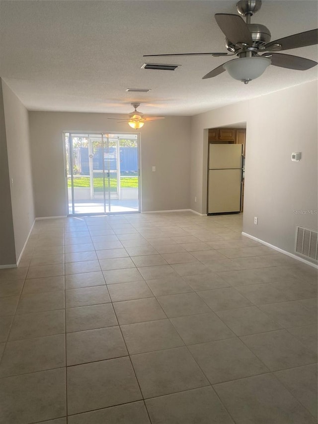 tiled spare room with ceiling fan