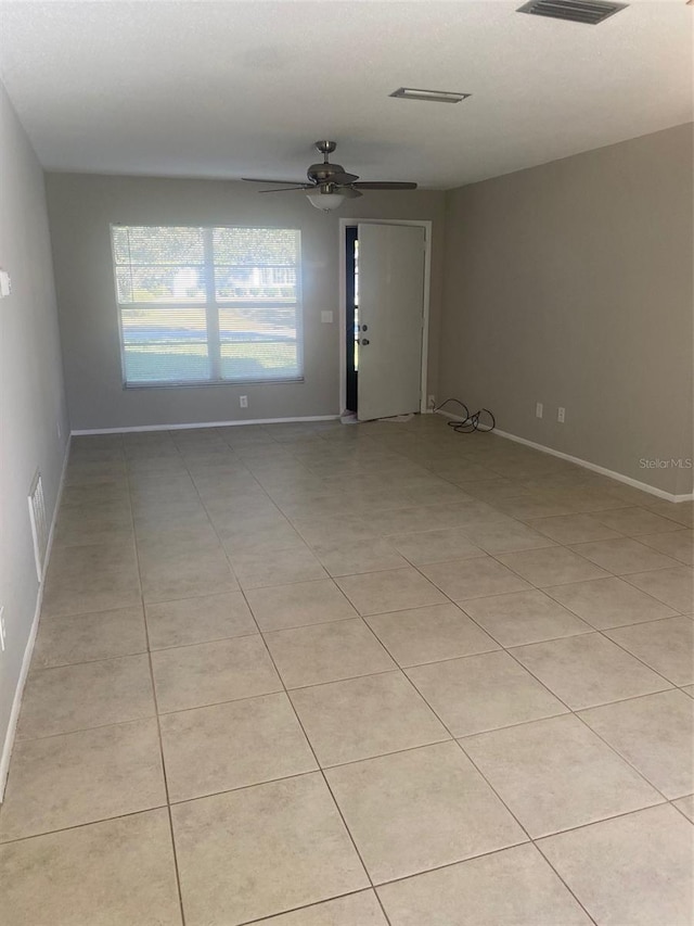 tiled empty room featuring ceiling fan