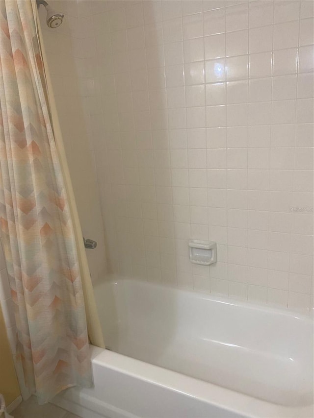 bathroom featuring tile patterned flooring and shower / bathtub combination with curtain