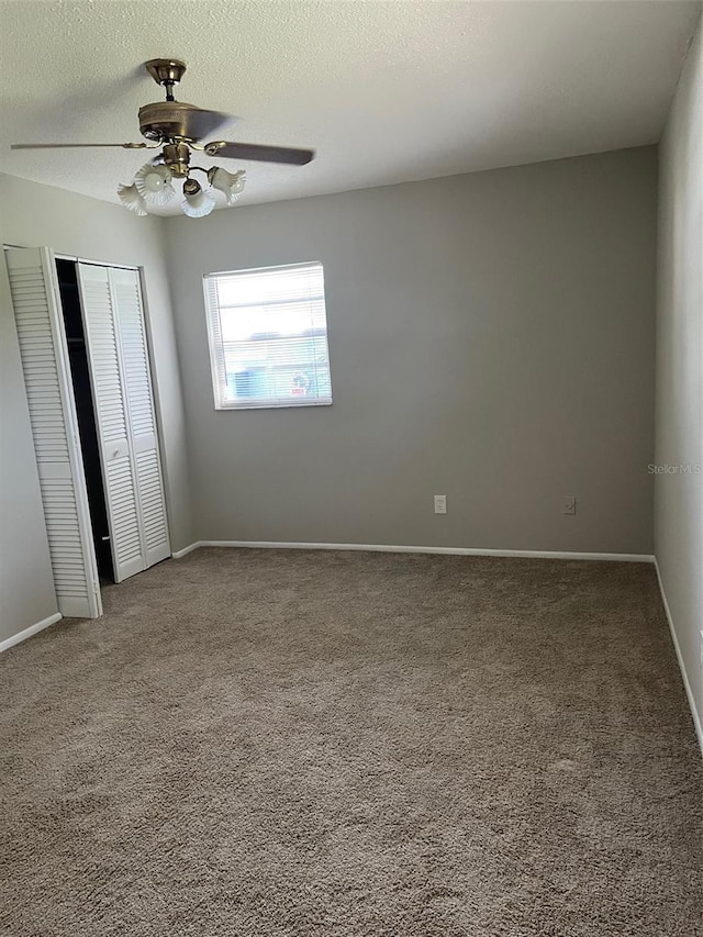 2408 Victory Palm Dr, Edgewater, FL 32141 - unfurnished bedroom featuring carpet, a closet, a ceiling fan, a textured ceiling, and baseboards