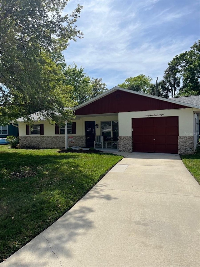 2408 Victory Palm Dr, Edgewater, FL 32141 - single story home featuring stone siding, an attached garage, a front yard, and concrete driveway