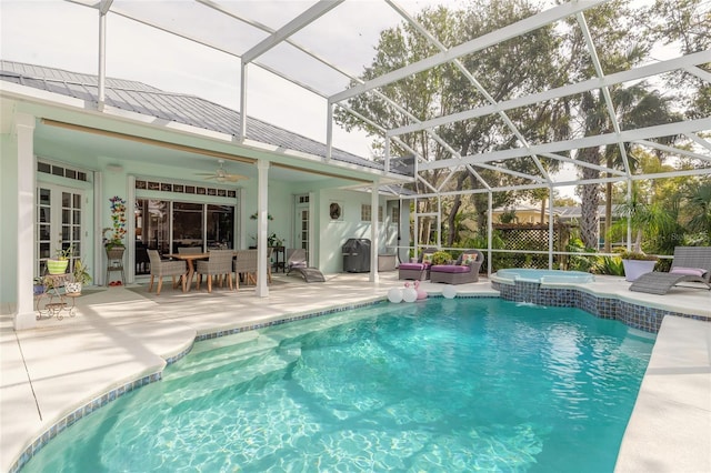 view of pool featuring ceiling fan, glass enclosure, an in ground hot tub, and a patio