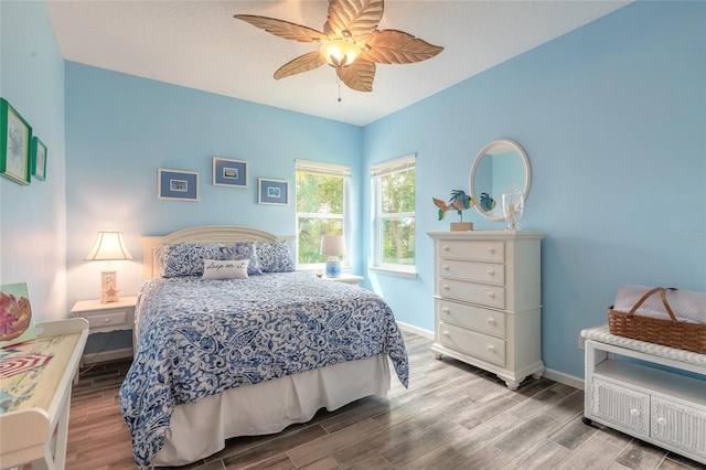 bedroom with ceiling fan, a textured ceiling, and light hardwood / wood-style flooring