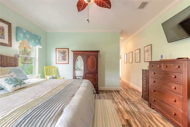 bedroom featuring ceiling fan, ornamental molding, and hardwood / wood-style floors