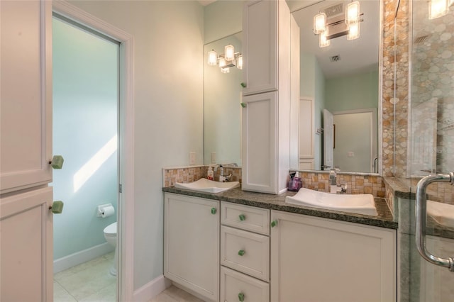 bathroom featuring tasteful backsplash, vanity, an enclosed shower, and toilet