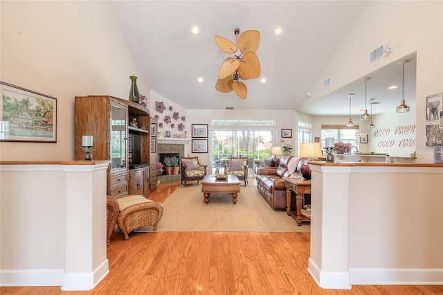 living room featuring ceiling fan, light hardwood / wood-style floors, and high vaulted ceiling