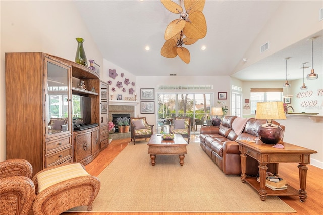 living room with ceiling fan, light hardwood / wood-style floors, and high vaulted ceiling