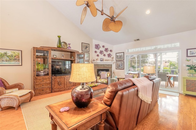 living room with light hardwood / wood-style floors, lofted ceiling, and ceiling fan