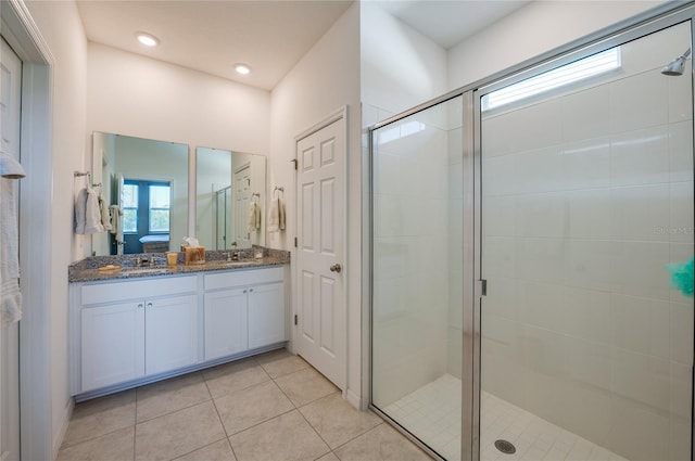 bathroom featuring a shower with door, vanity, and tile patterned flooring