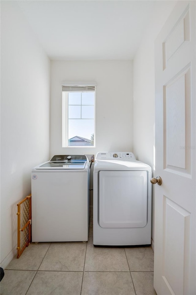 washroom with light tile patterned floors and washing machine and clothes dryer