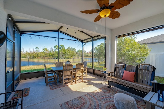 sunroom / solarium with ceiling fan, lofted ceiling, and a water view