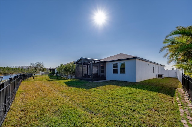 exterior space featuring glass enclosure, central AC unit, and a yard