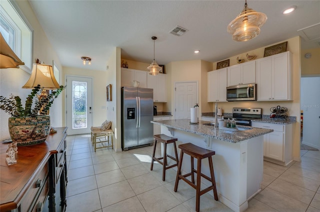 kitchen featuring appliances with stainless steel finishes, pendant lighting, and white cabinets