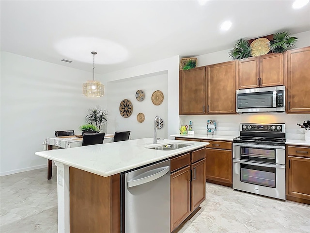 kitchen with hanging light fixtures, stainless steel appliances, a sink, and light countertops