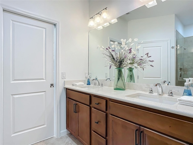 full bath with double vanity, tiled shower, and a sink