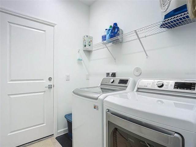 laundry room featuring laundry area, baseboards, and washing machine and clothes dryer