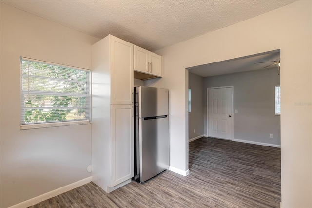 kitchen with ceiling fan, hardwood / wood-style floors, white cabinetry, a textured ceiling, and stainless steel fridge