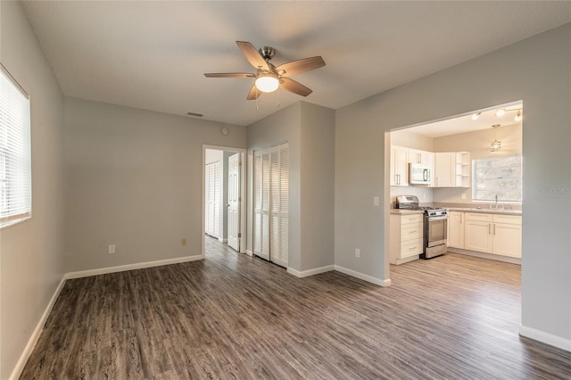 unfurnished living room with hardwood / wood-style flooring, sink, and ceiling fan