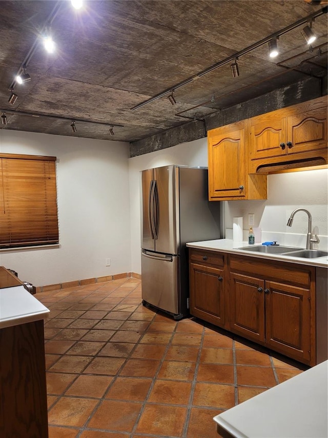 kitchen featuring stainless steel refrigerator, rail lighting, and sink