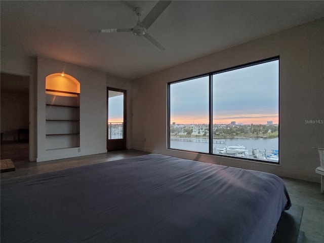 unfurnished bedroom with ceiling fan and a water view