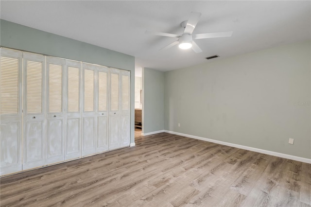 unfurnished bedroom featuring a closet, ceiling fan, and light wood-type flooring