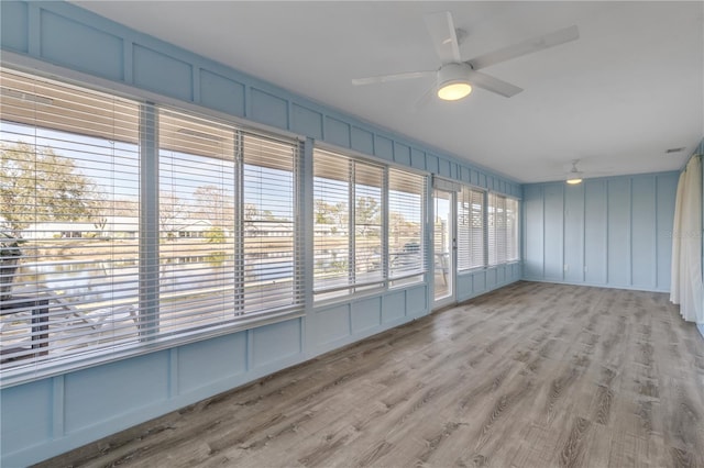 unfurnished sunroom with ceiling fan