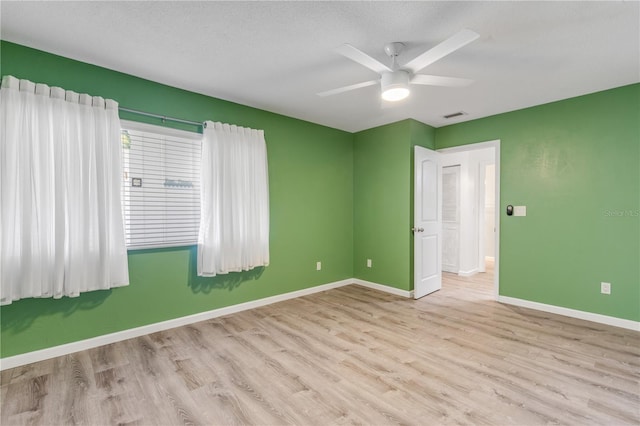 spare room featuring ceiling fan, a textured ceiling, and light wood-type flooring