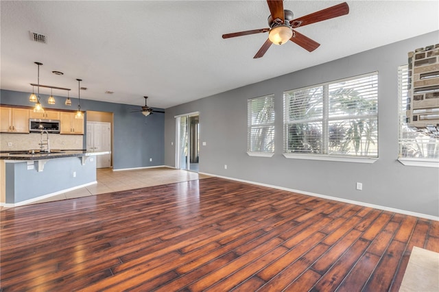 2707 Atlantis Dr, New Smyrna Beach, FL 32168 - unfurnished living room featuring a textured ceiling, light hardwood / wood-style flooring, and ceiling fan