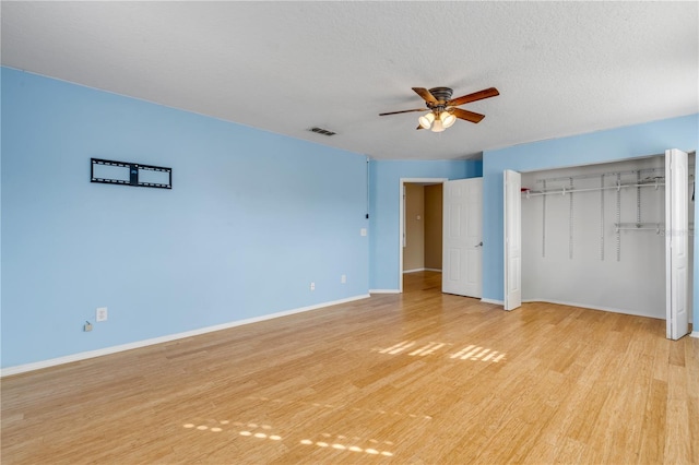 2707 Atlantis Dr, New Smyrna Beach, FL 32168 - unfurnished bedroom featuring ceiling fan, a textured ceiling, a closet, and light wood-type flooring
