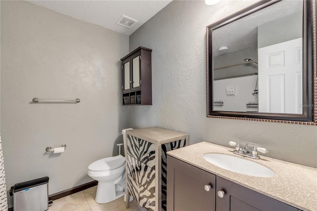 2707 Atlantis Dr, New Smyrna Beach, FL 32168 - bathroom with tile patterned floors, toilet, a textured ceiling, and vanity