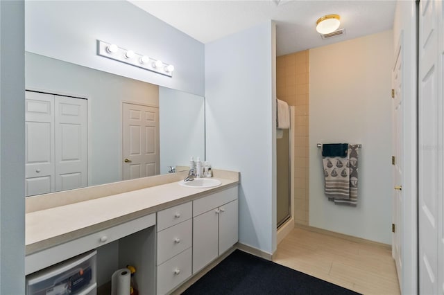 bathroom with vanity and a shower with door