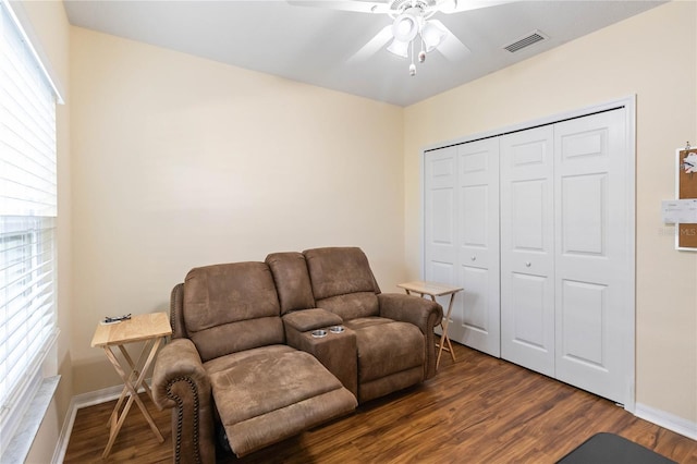 living room with ceiling fan, dark wood-type flooring, and a healthy amount of sunlight