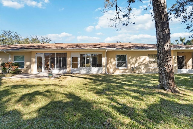 rear view of house with a yard and a patio area