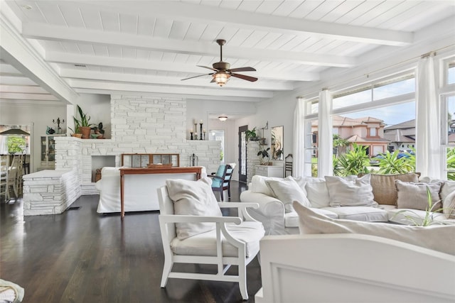 living room featuring ceiling fan, dark hardwood / wood-style floors, beam ceiling, and a fireplace