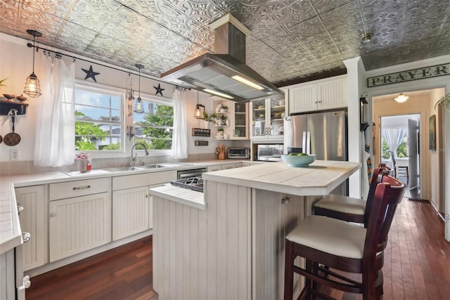 kitchen with island range hood, stainless steel refrigerator with ice dispenser, a kitchen island, pendant lighting, and white cabinets